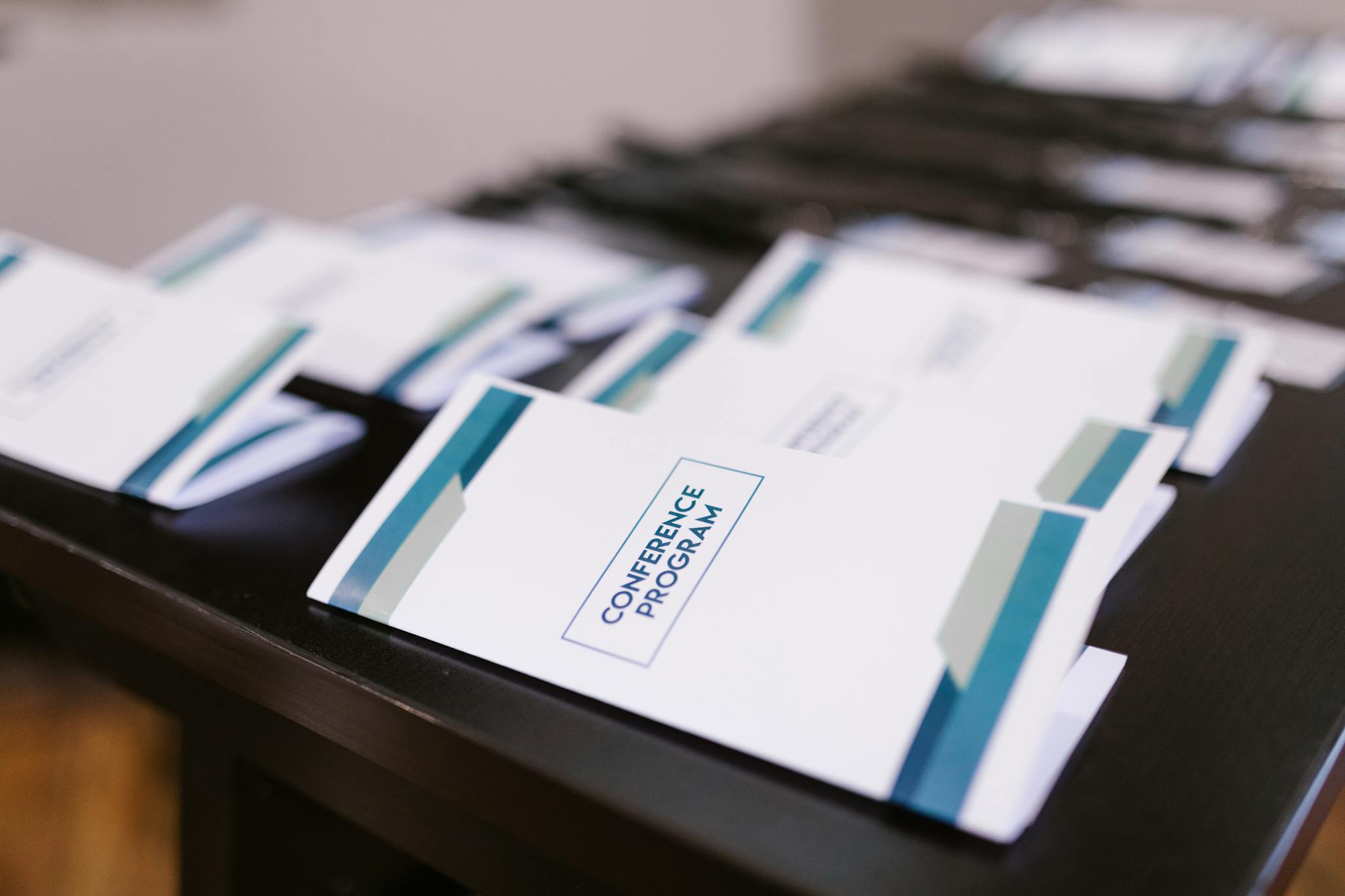 Close-up of conference program booklets neatly arranged on a table, indoors.