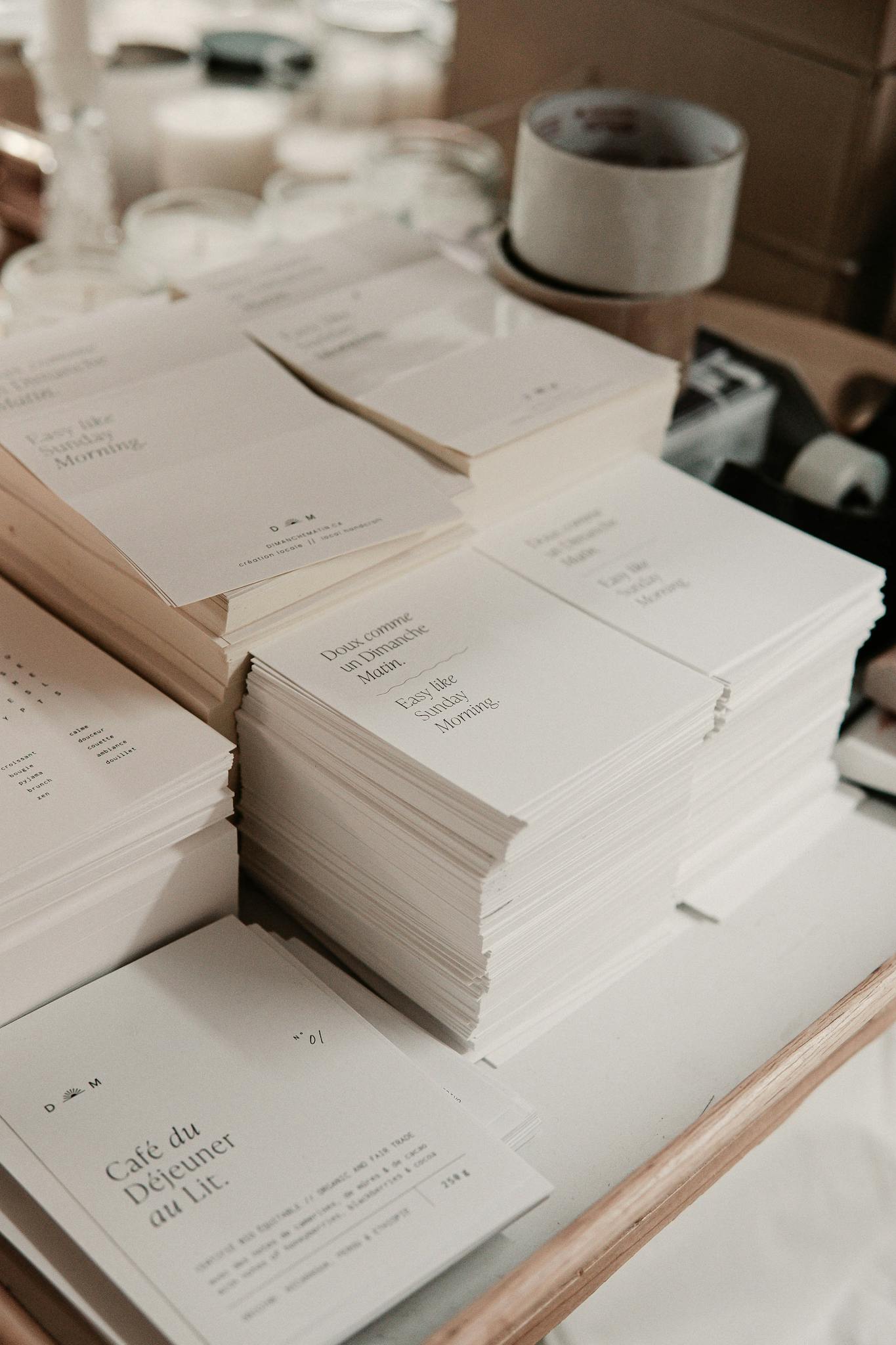 Stacks of minimalist printed invitations organized in a studio setting, ideal for business and design concepts.